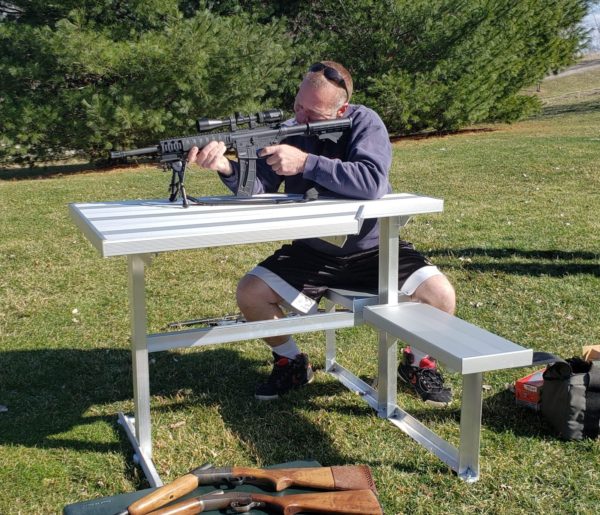 Adult left handed marksman using the all weather outdoor aluminum marksman shooting bench