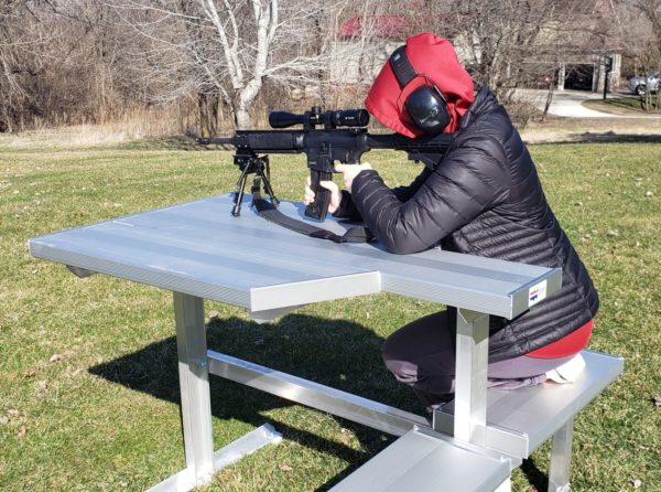 Left handed female marksman with the outdoor UMB aluminum shooting marksman bench